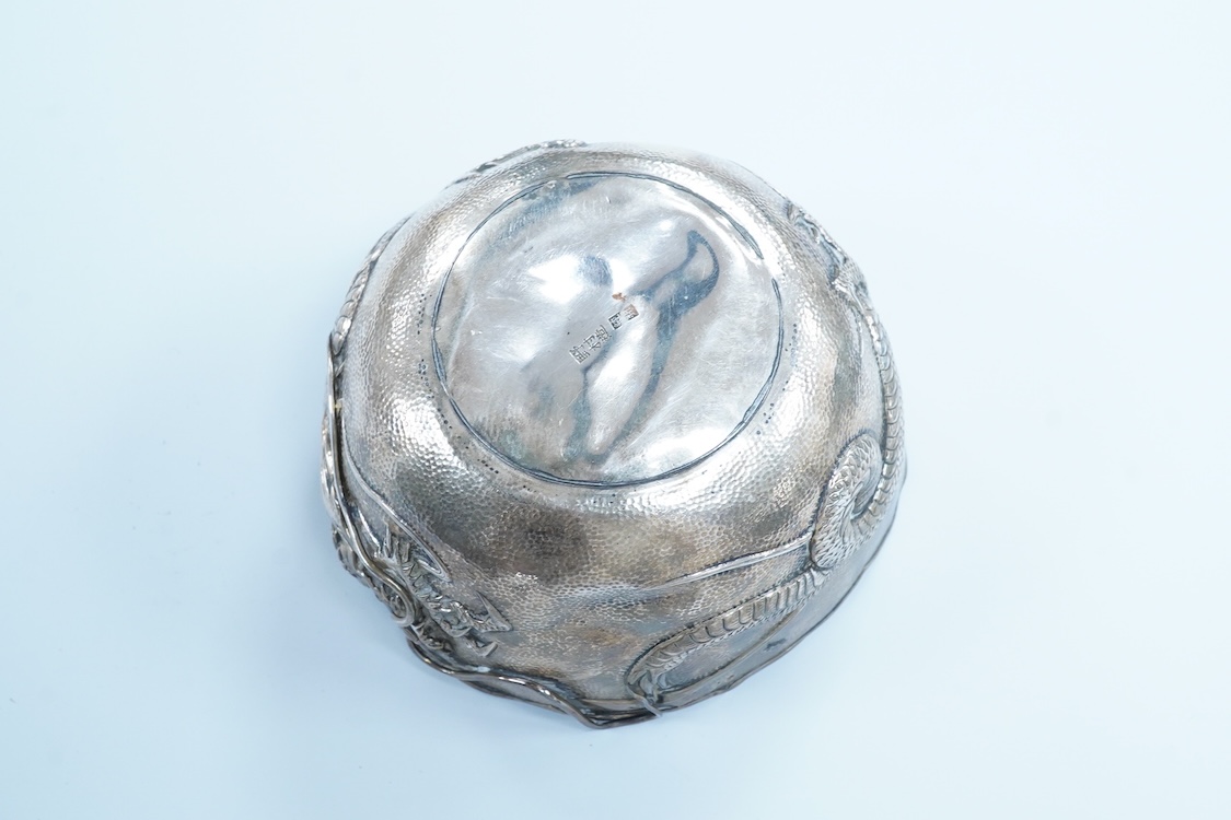 An early 20th century Japanese planished white metal double walled sugar bowl, decorated with the continuous scene of a dragon, signed to the base, diameter 12.1cm, 5.9oz(a.f.).